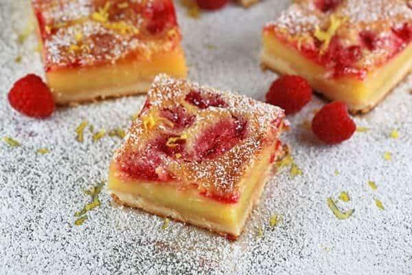 Lemon bars on a sheet pan covered in powdered sugar