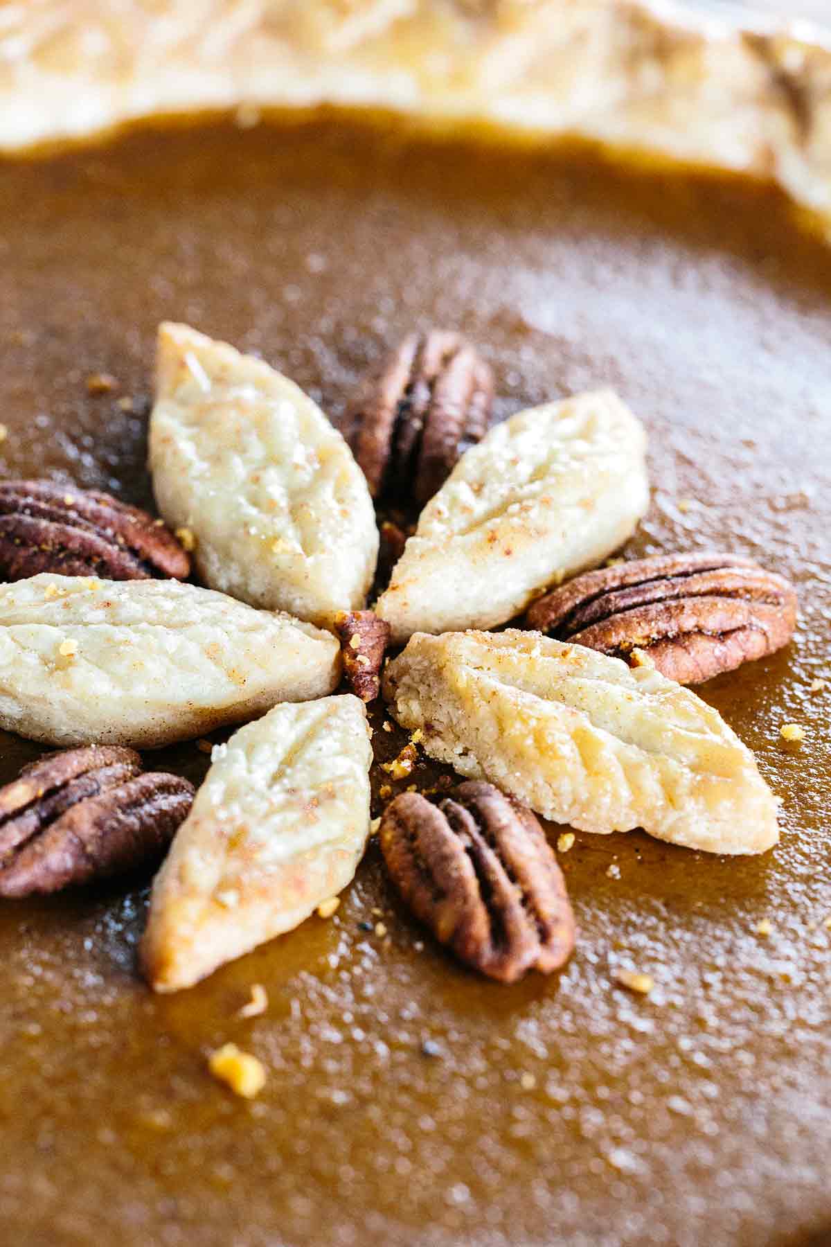 Five leaves on top of a pumpkin pie created with extra dough.