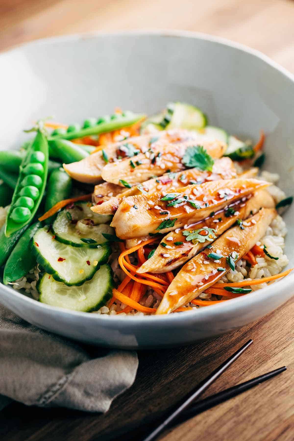 sesame soy glazed chicken with vegetables and rice in bowl