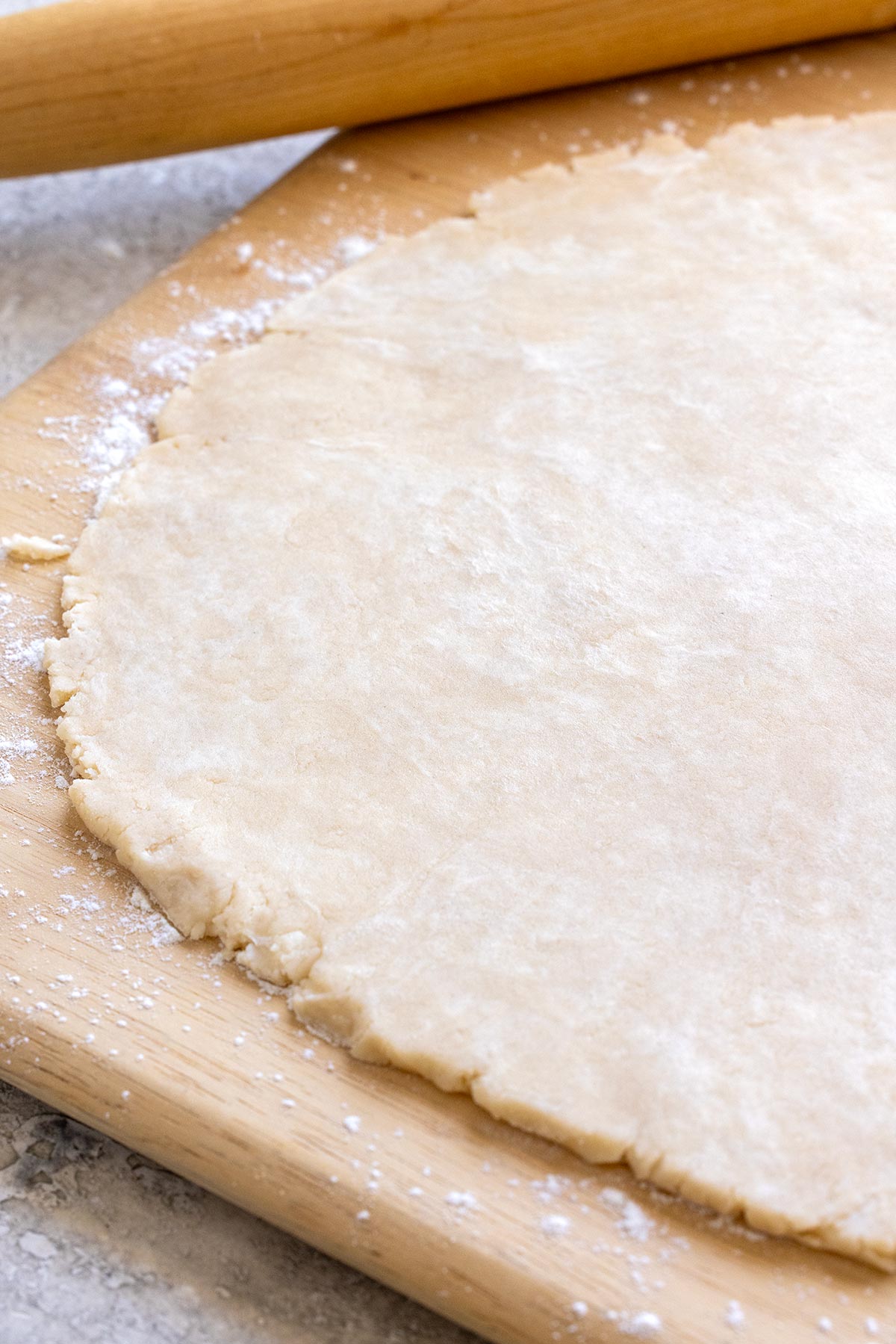 Pie dough on a floured surface rolled into a circle.