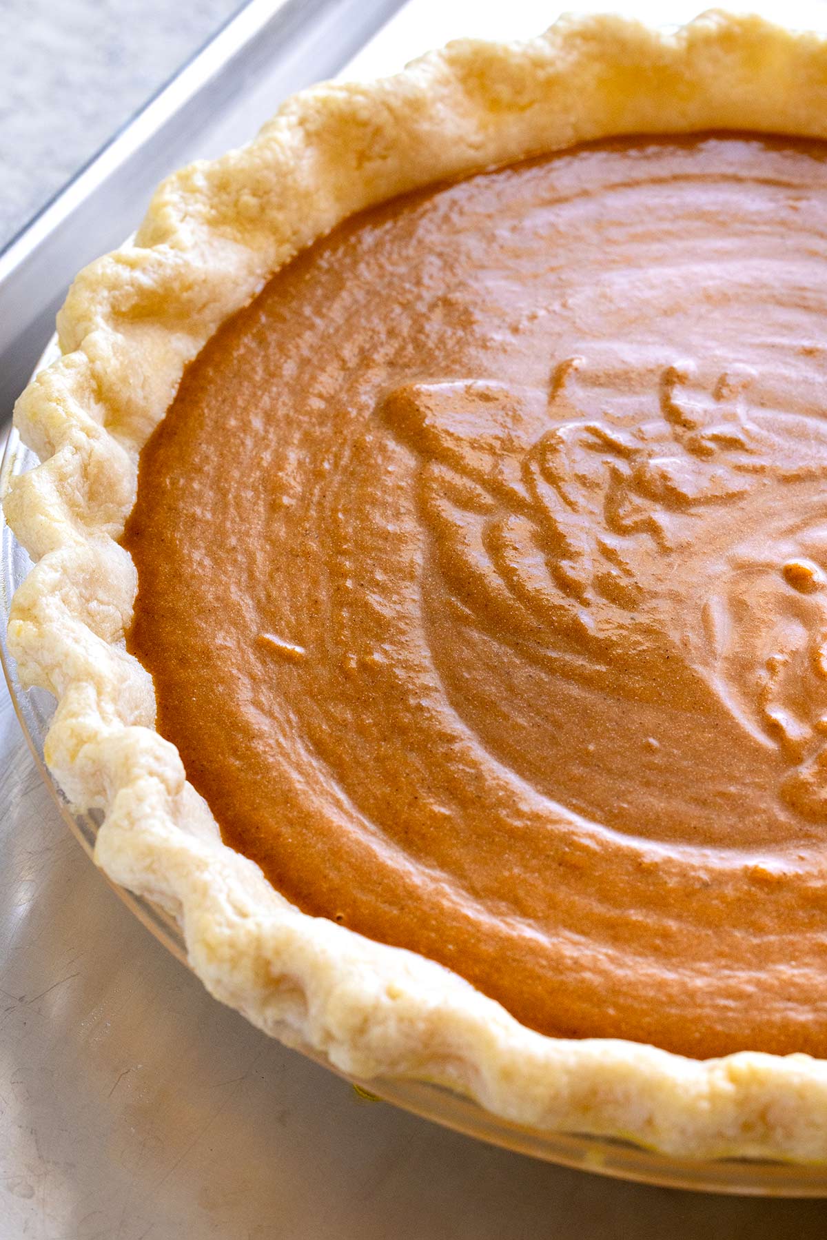 Pumpkin pie filling placed in a pie crust.