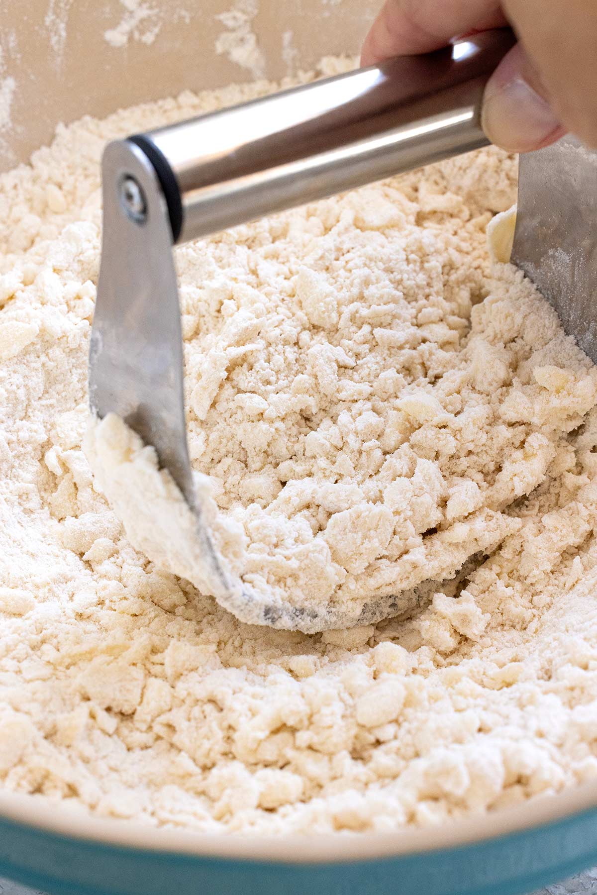 Pastry cutter mixing butter and flour together.