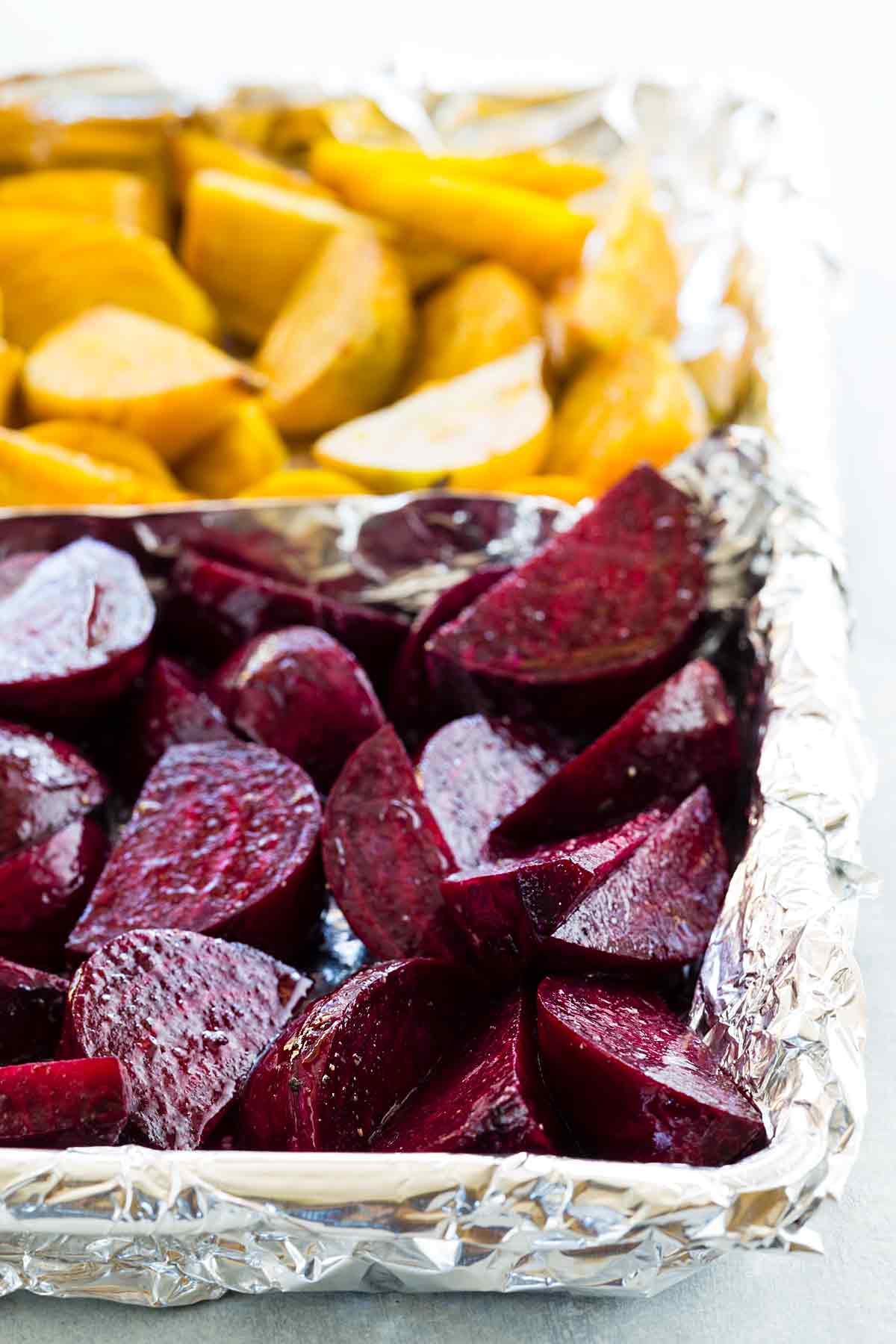 Sheet pan with oiled and salted red and golden beets.