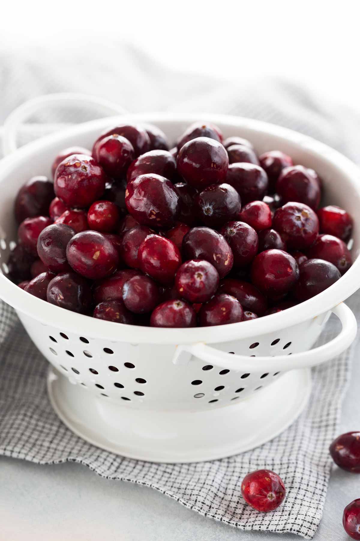 Fresh cranberries inside a white colander.