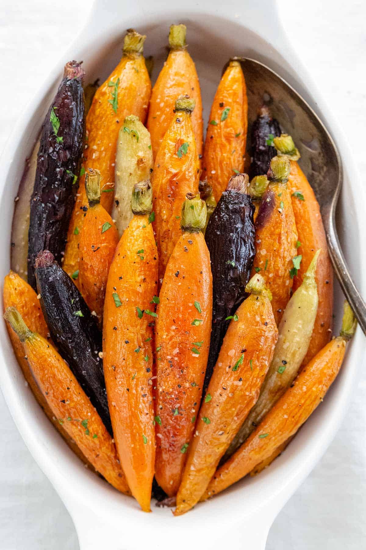 Roasted carrots in a white serving bowl.