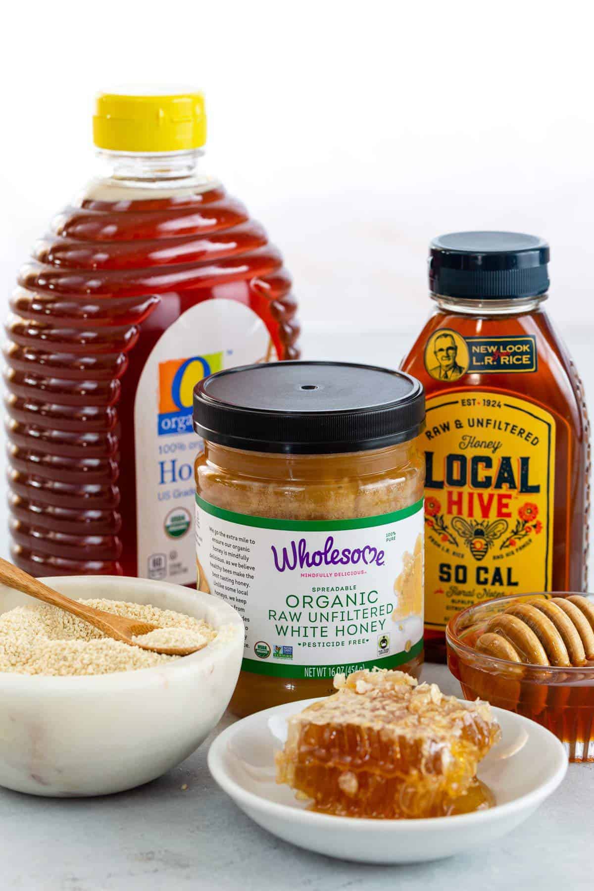 Different types of honey in jars and bowls.