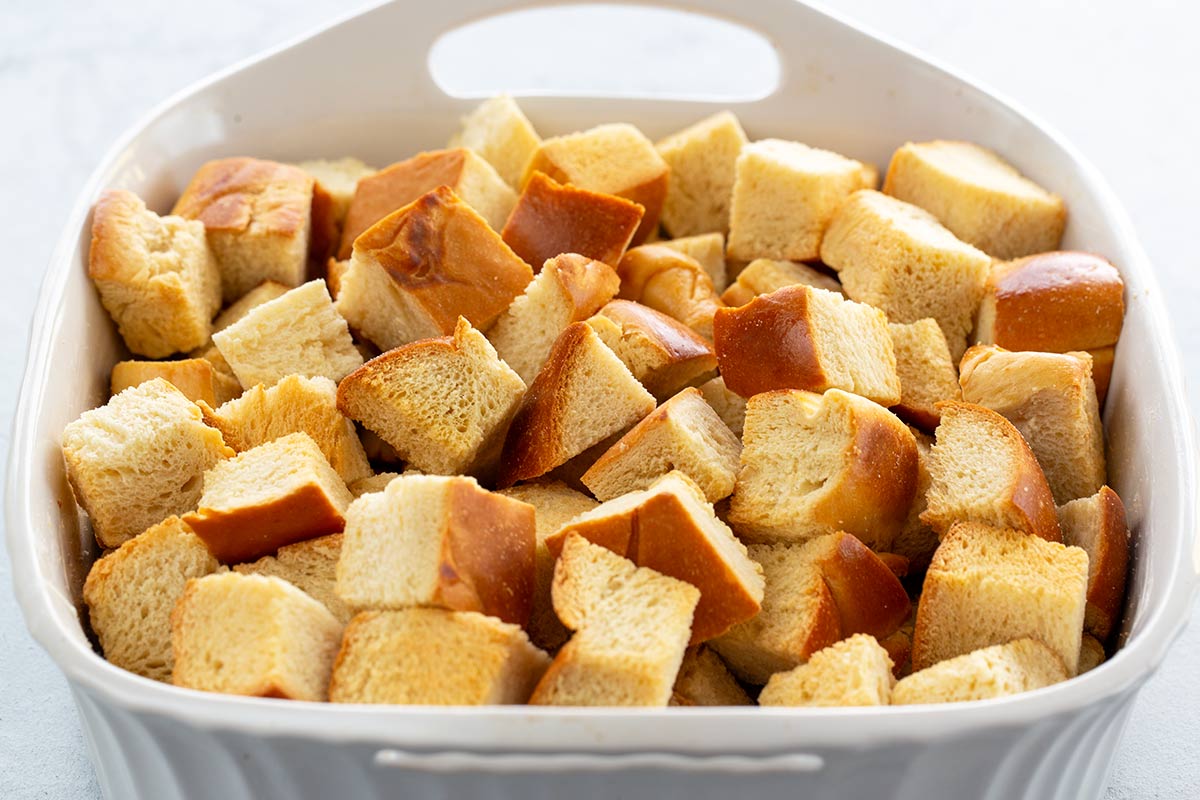 Cubes of toasted bread inside a white casserole dish.
