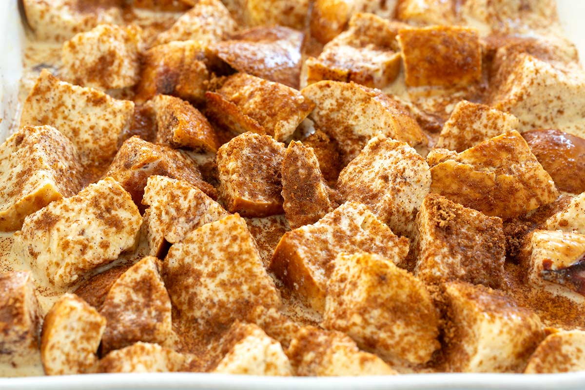 Cinnamon and sugar mixture sprinkled over top cubes of soaked bread.