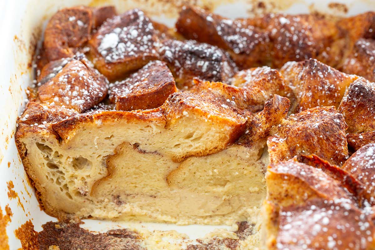 A portion of French toast casserole removed showing the inside of a slice.