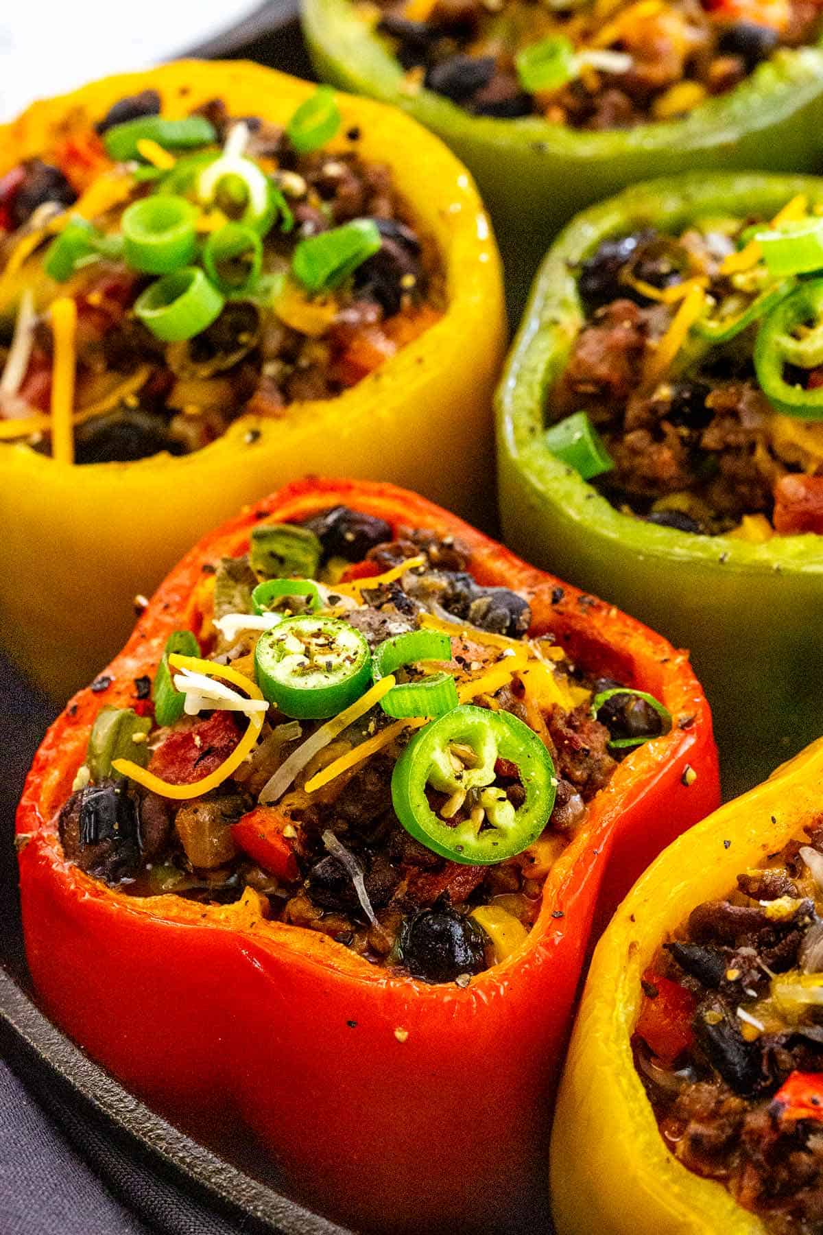 Melted cheese on top of stuffed bell peppers.