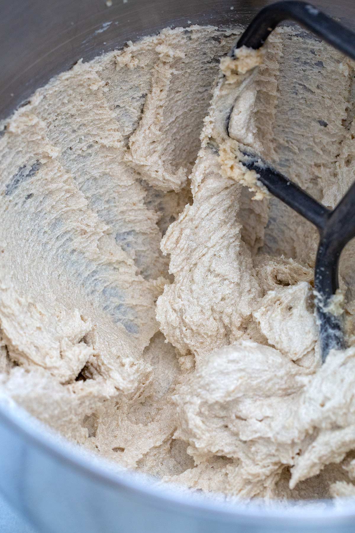 Butter and sugar being mixed together in a stand mixer bowl.