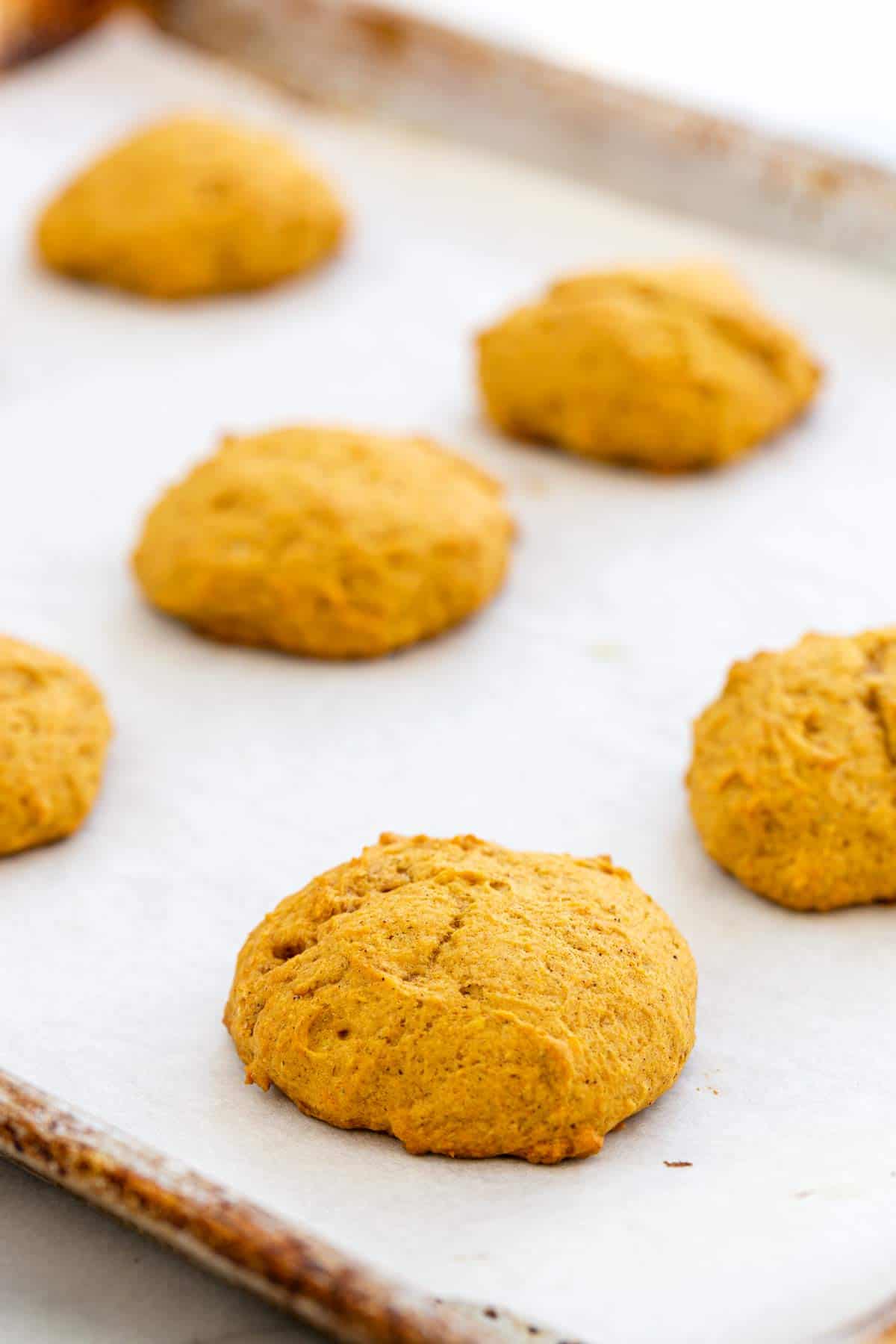 Baked pumpkin cookies on parchment paper.