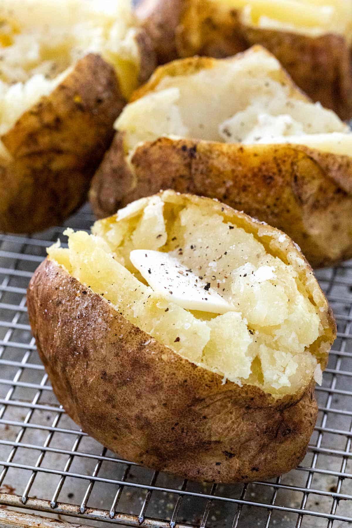 Opened baked potato with a pad of butter.