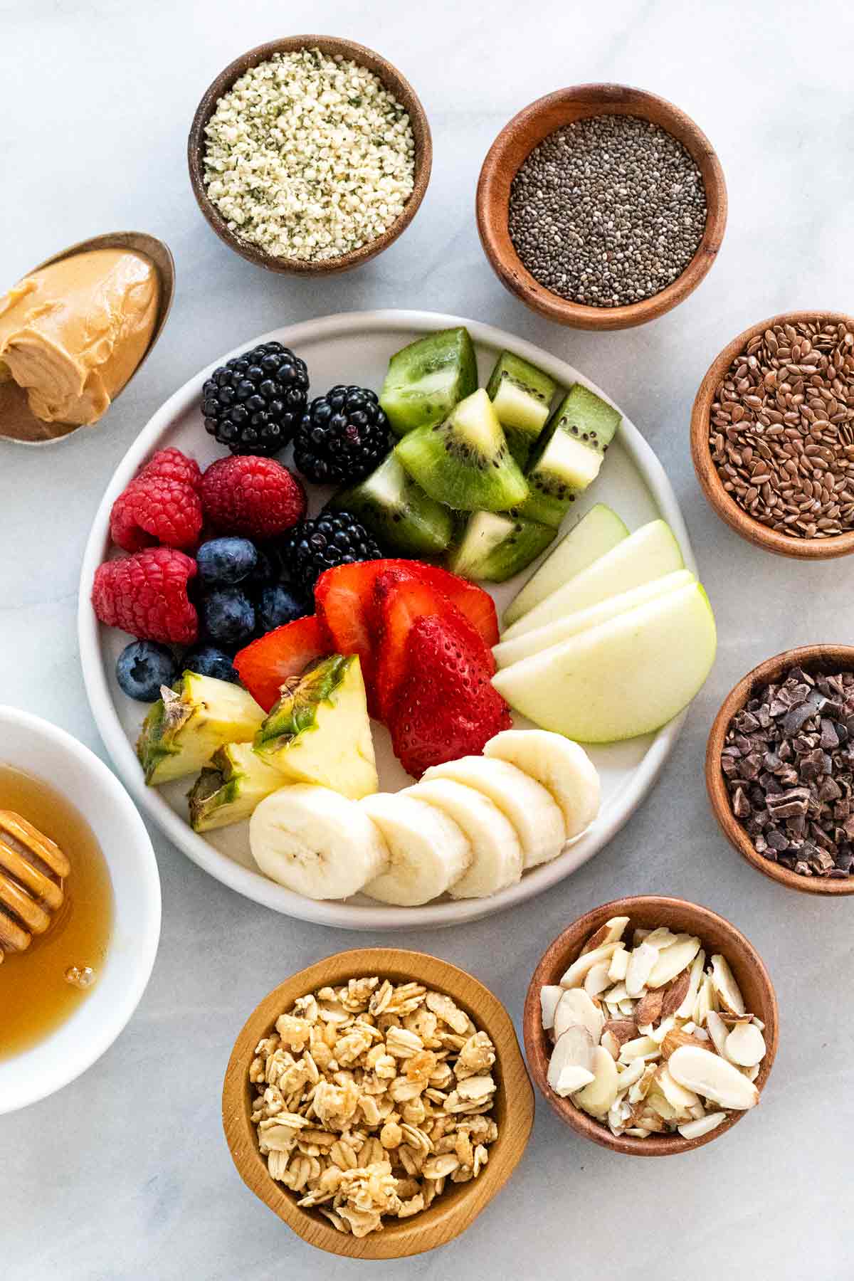 Various homemade acai bowl topping ideas including seeds and fruit.