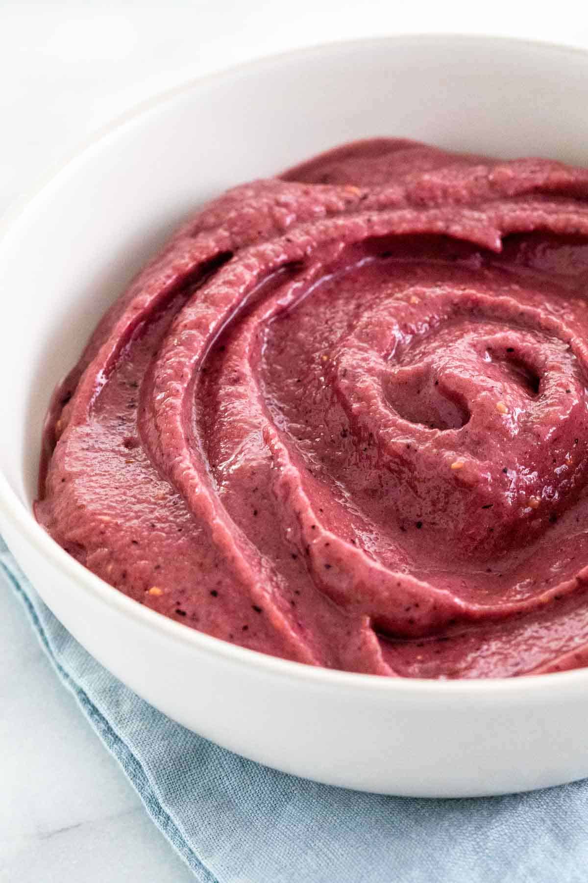 Blended acai smoothie in a white bowl.