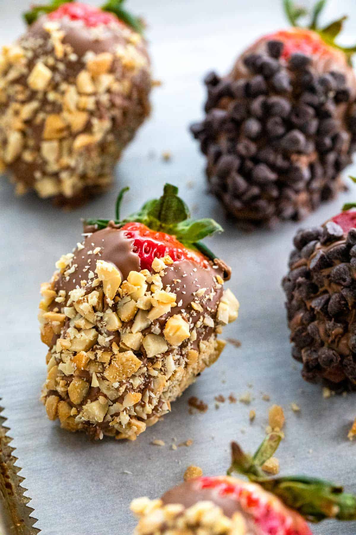 Chocolate covered strawberries dipped in nuts and chocolate chips.