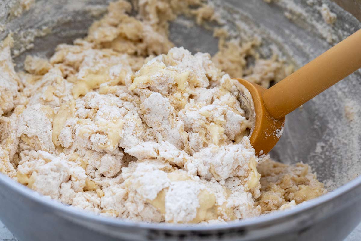 Spoon mixing a yeast and flour in a bowl.