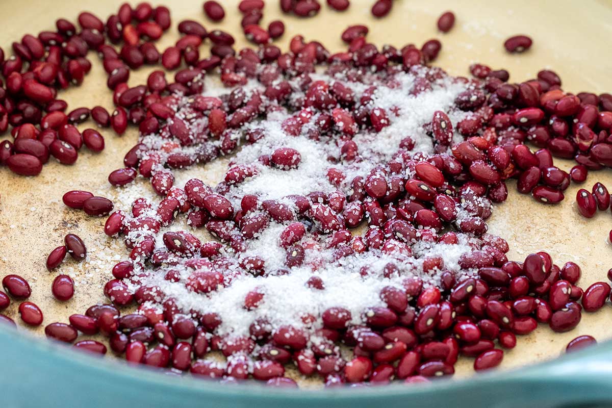 Dried red kidney beans in a pot sprinkled with coarse salt.