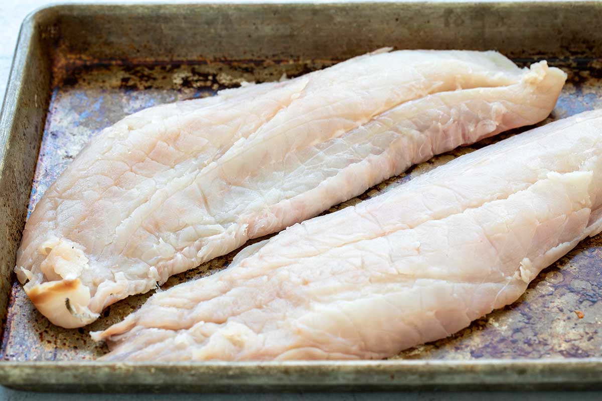 Two fillets of fish on a baking sheet.