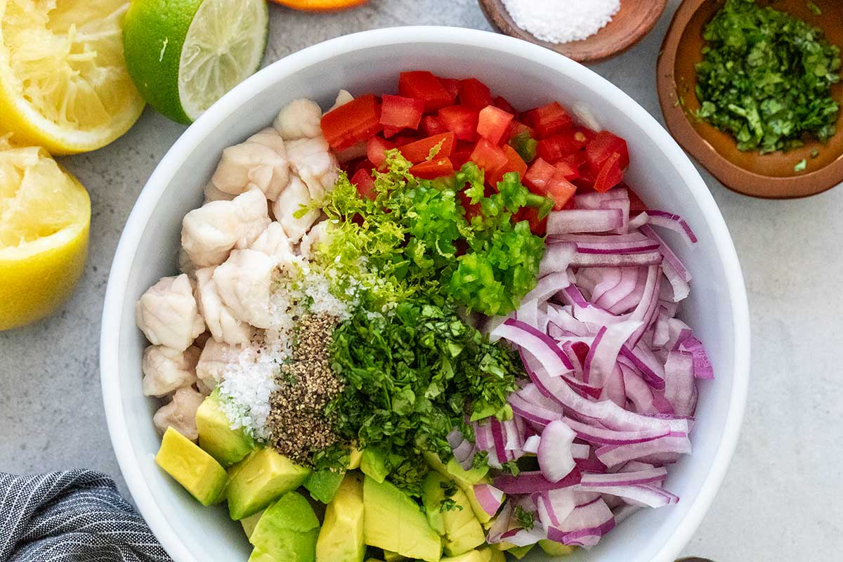 Top down view of a bowl of unmixed ceviche ingredients.