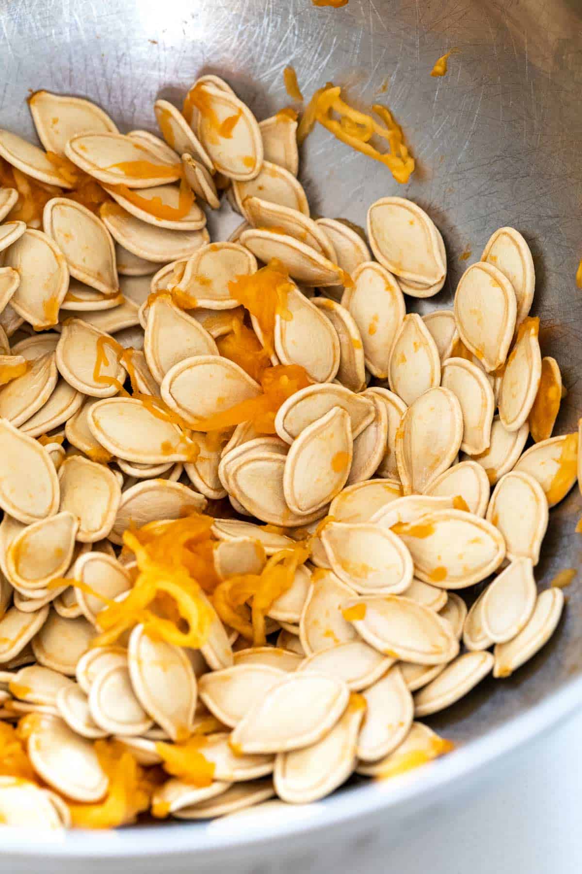 Freshly removed pumpkin seeds in a bowl.