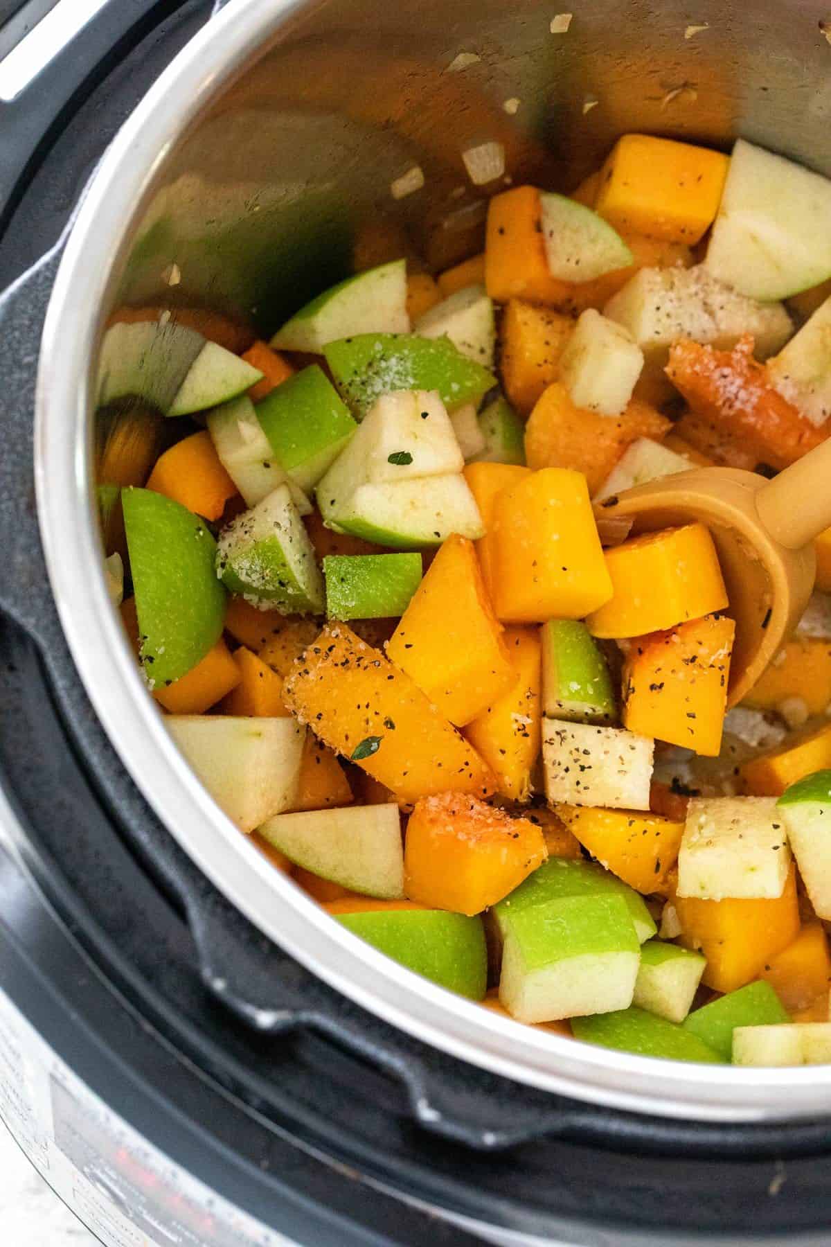 Diced apples and butternut squash cubes inside an Instant Pot device.