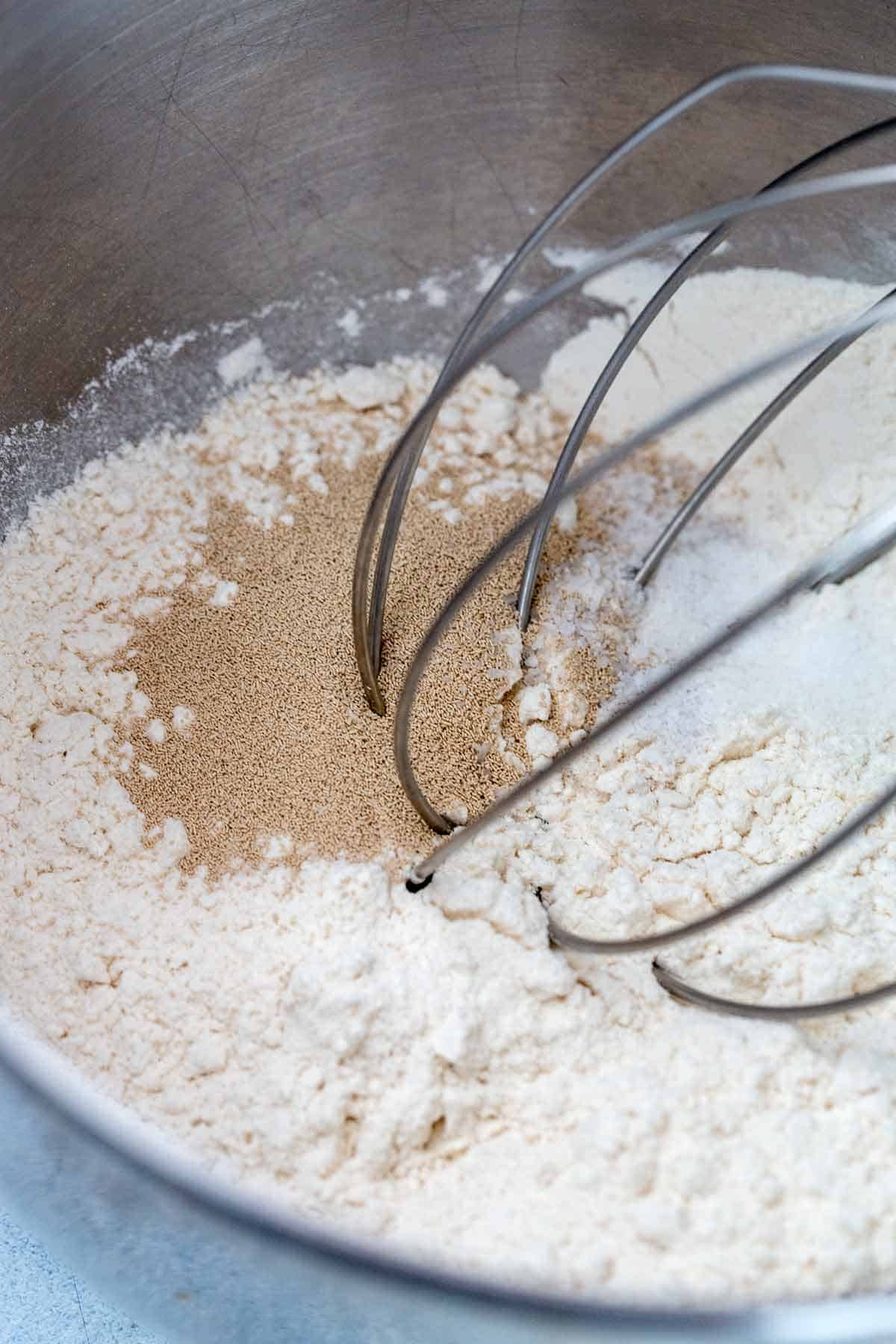 Instant dry yeast and flour in a stand mixer bowl.