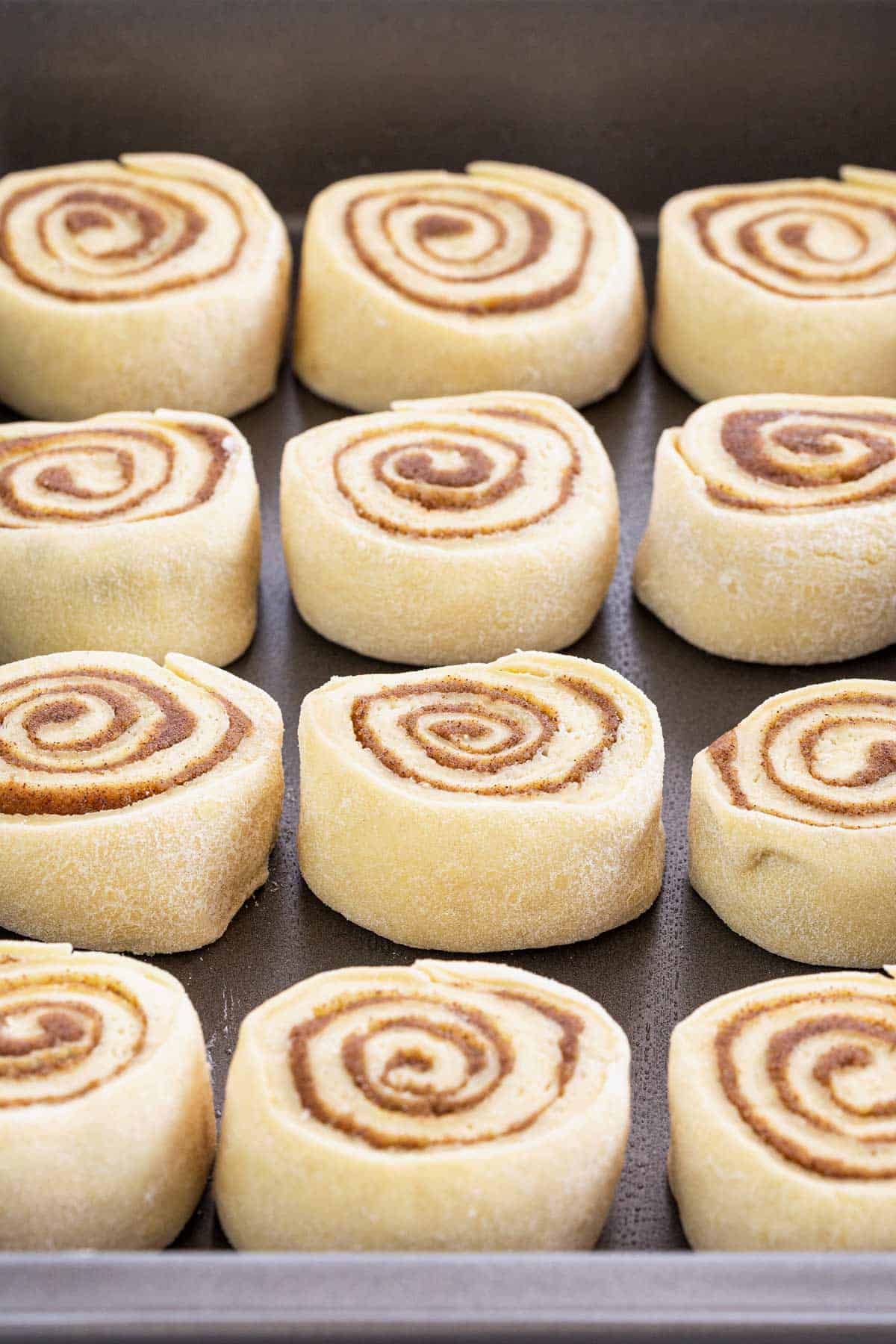Cinnamon rolls in a pan after cutting them.