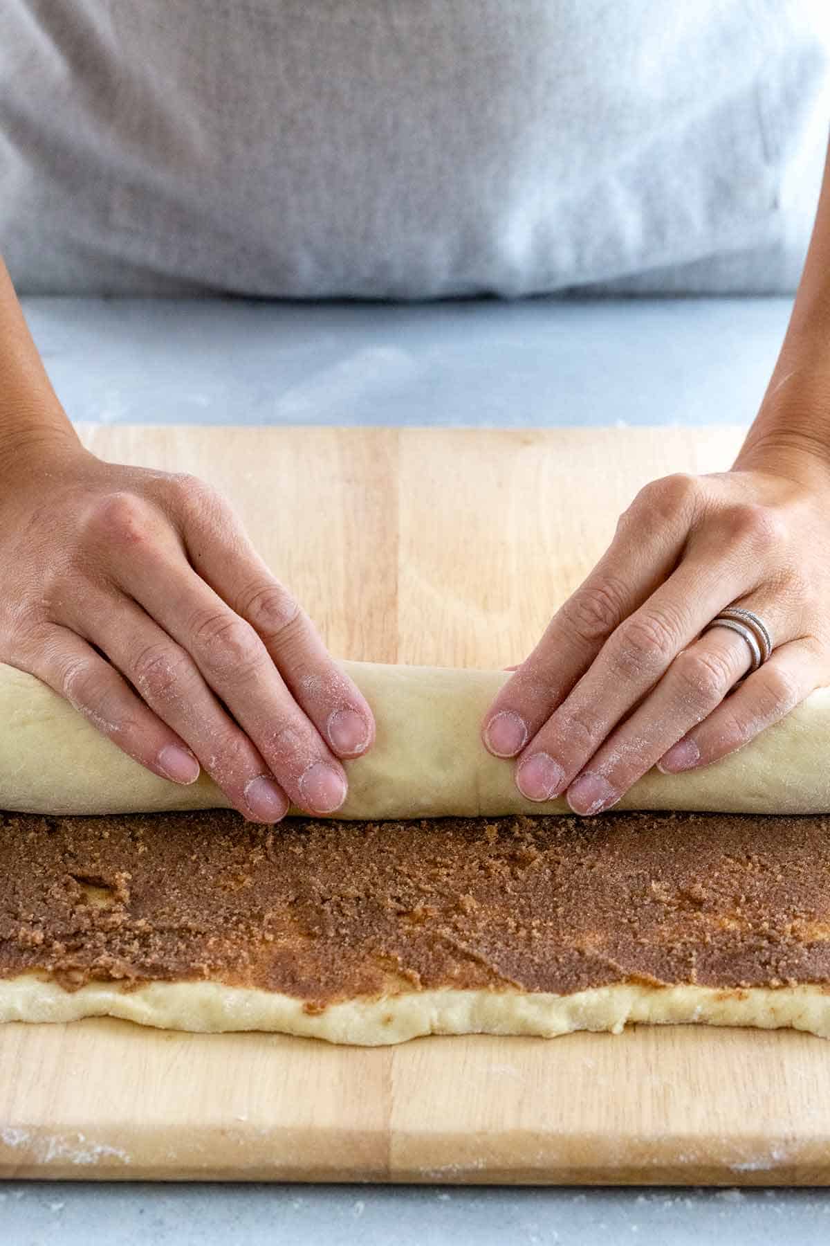 Rolling the dough into a tight cigar shape.