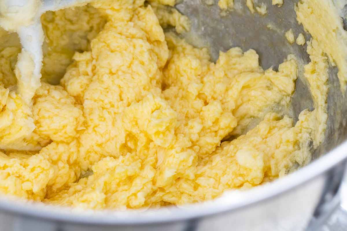 Butter, sugar, and eggs in a stand mixer bowl.