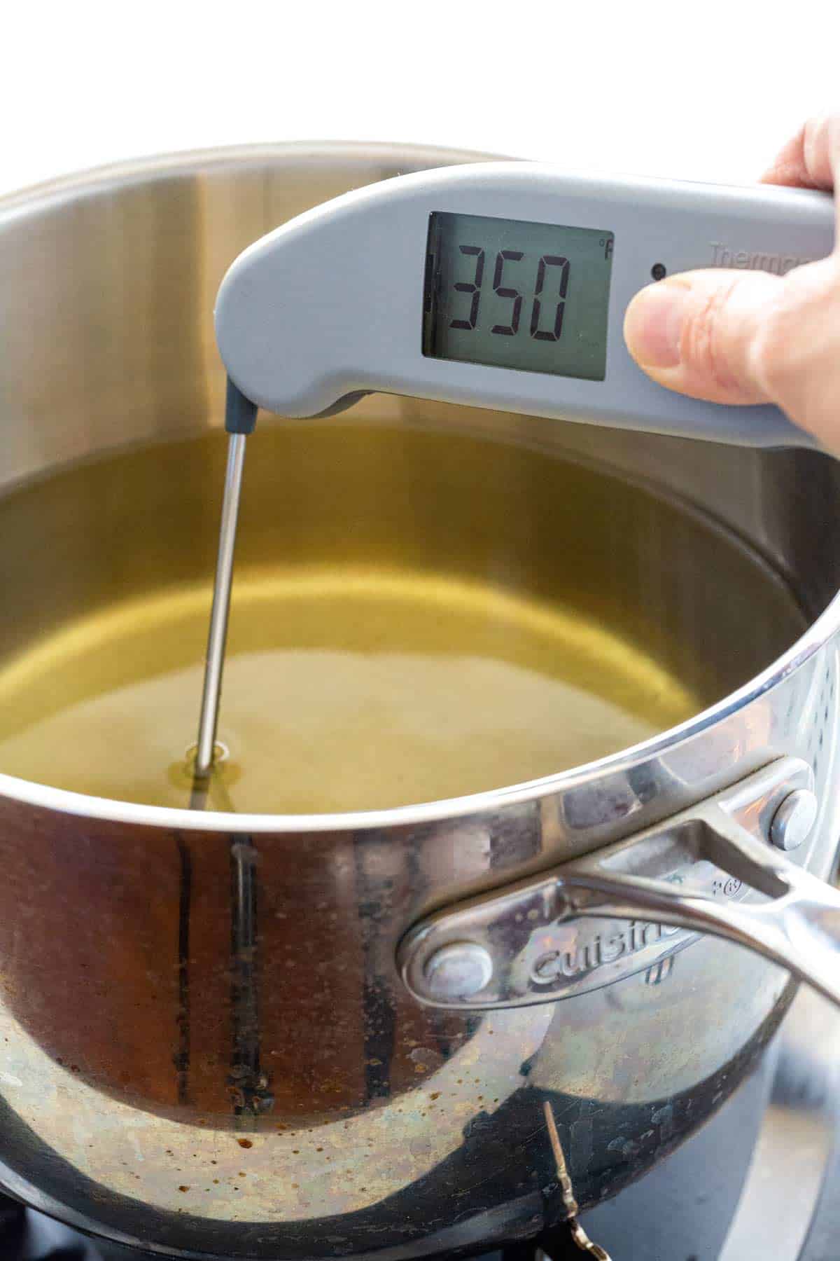 Checking the frying oil temperature with an instant-read thermometer reading 350ºF.