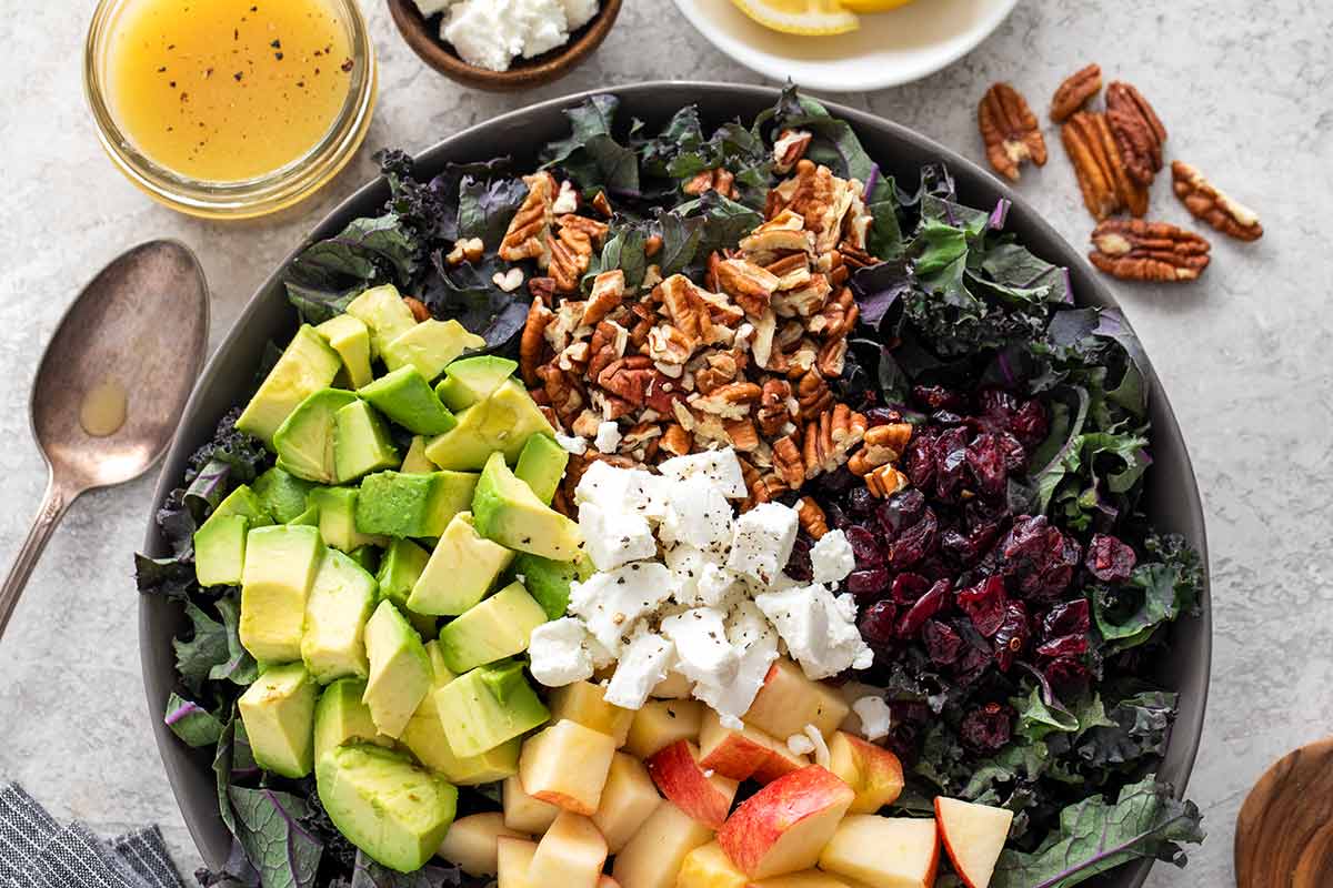 Colorful unmixed kale salad with each ingredient on top.