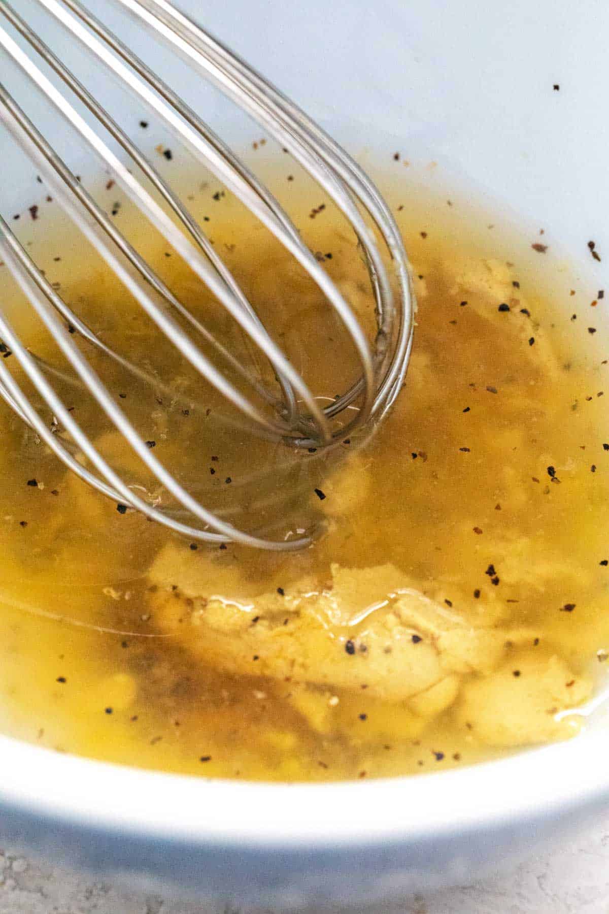 Whisk mixing together a salad dressing.