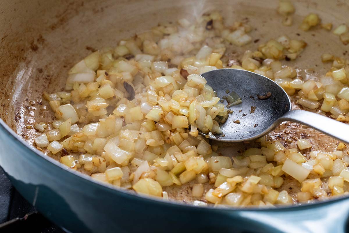 Diced onions and minced garlic sautéing in a pot.