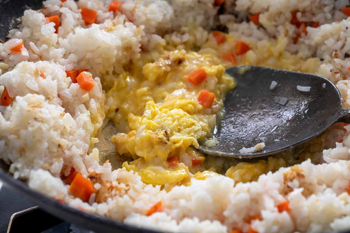 Scrambled eggs cooking in the middle of a pot of rice.