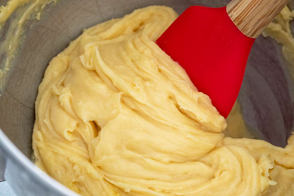 Puff pastry dough being mixed in a bowl with a spatula.