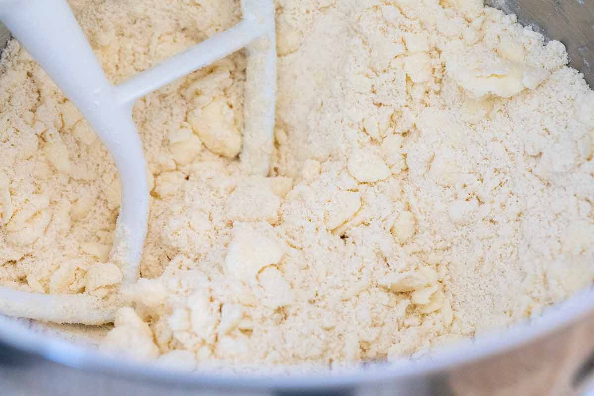 Butter being incorporated into flour and salt using a stand mixer.
