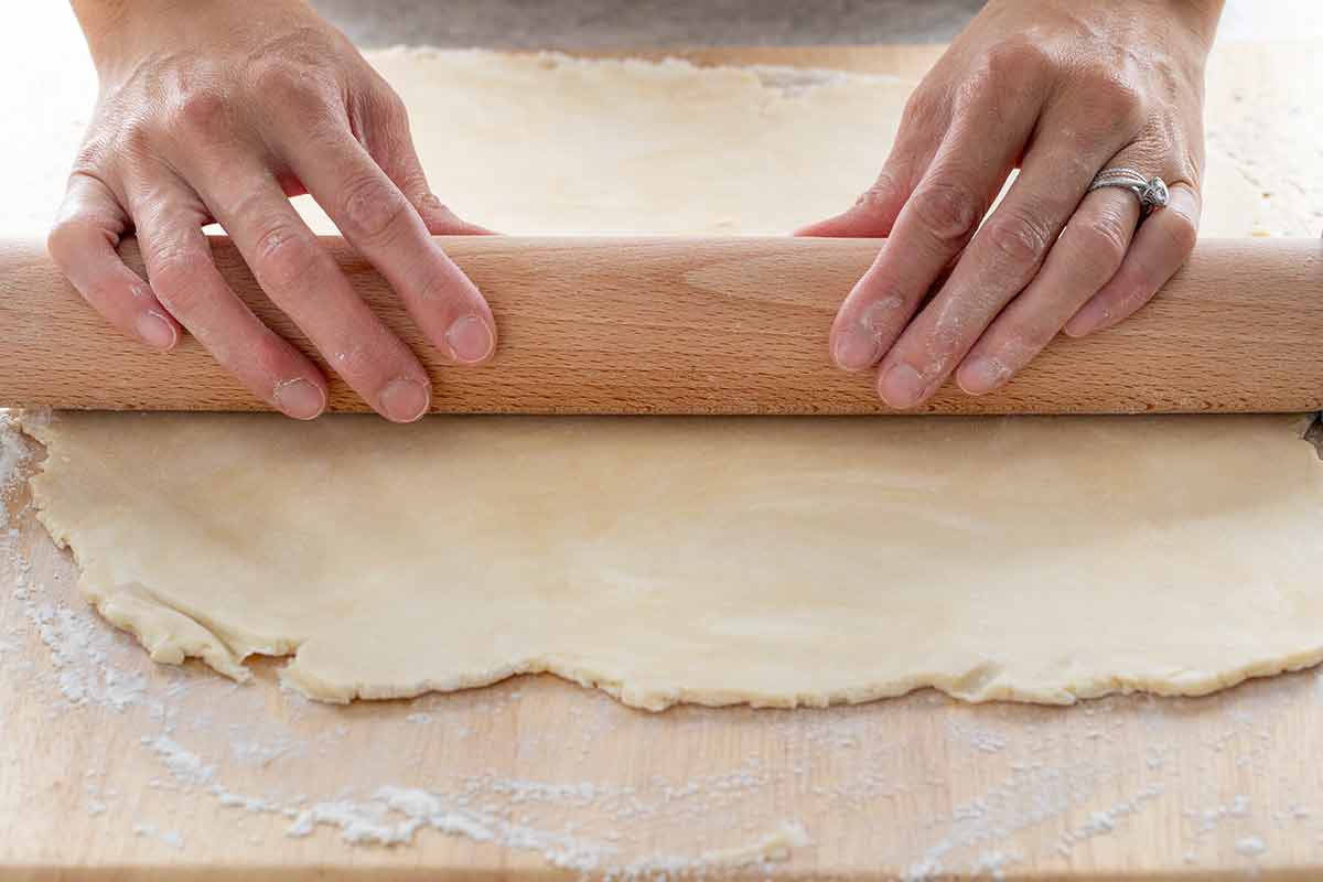 Jessica rolling out dough on a floored work surface.
