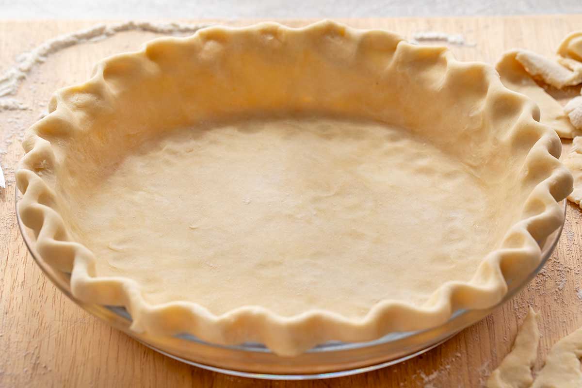Formed pie crust in a glass plate.