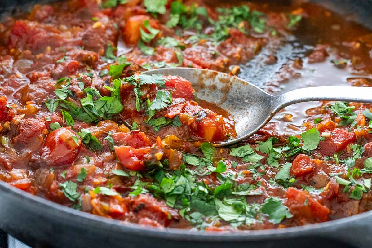 Homemade red tomato sauce simmering in a cast iron skillet.