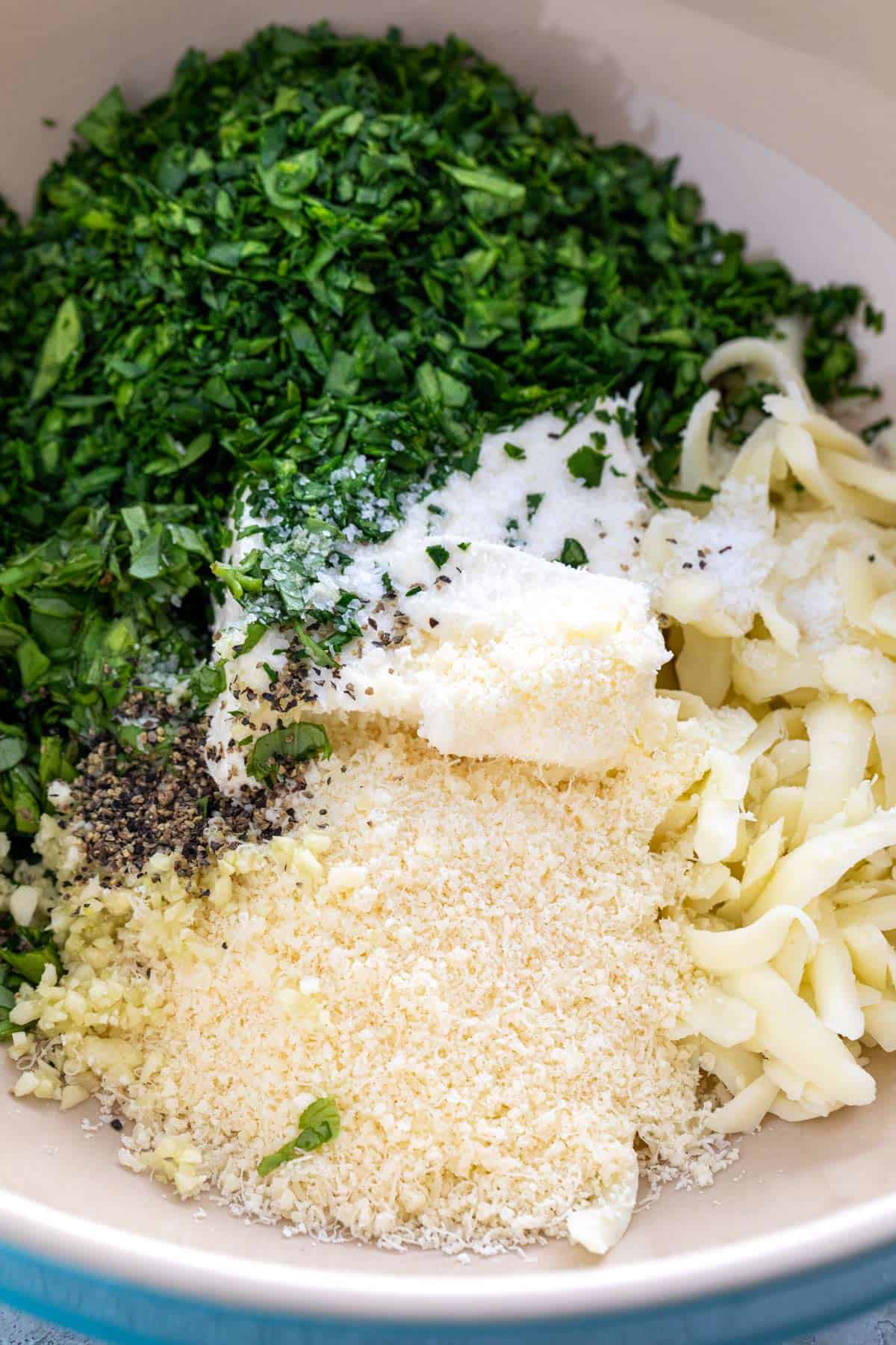 Unmixed spinach filling ingredients in a bowl.