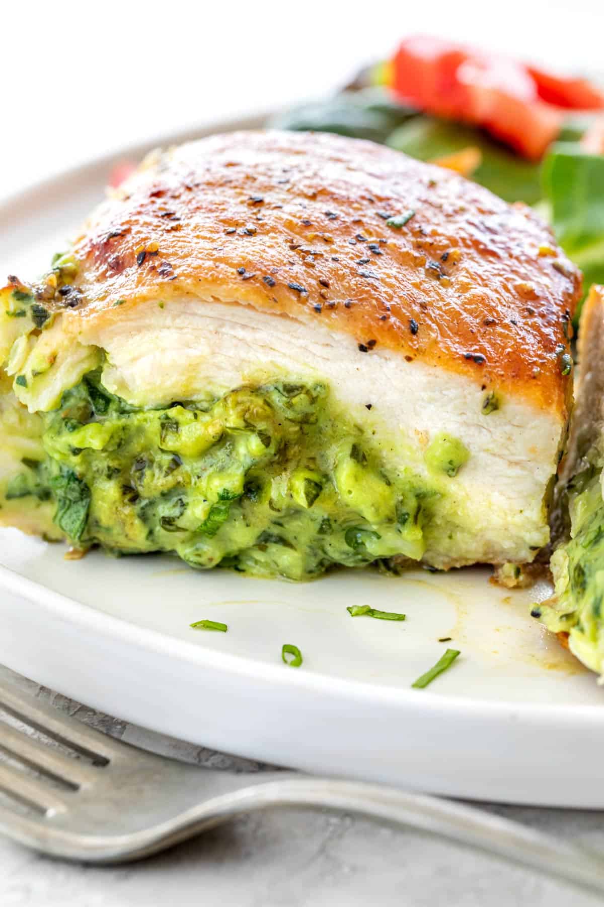 Chicken breast cut in half showing the spinach filling inside.