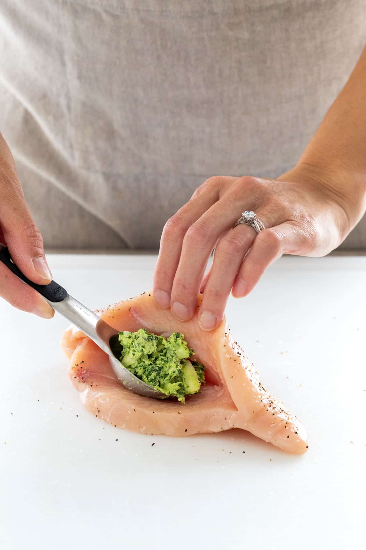 Stuffing spinach filling into a chicken breast.