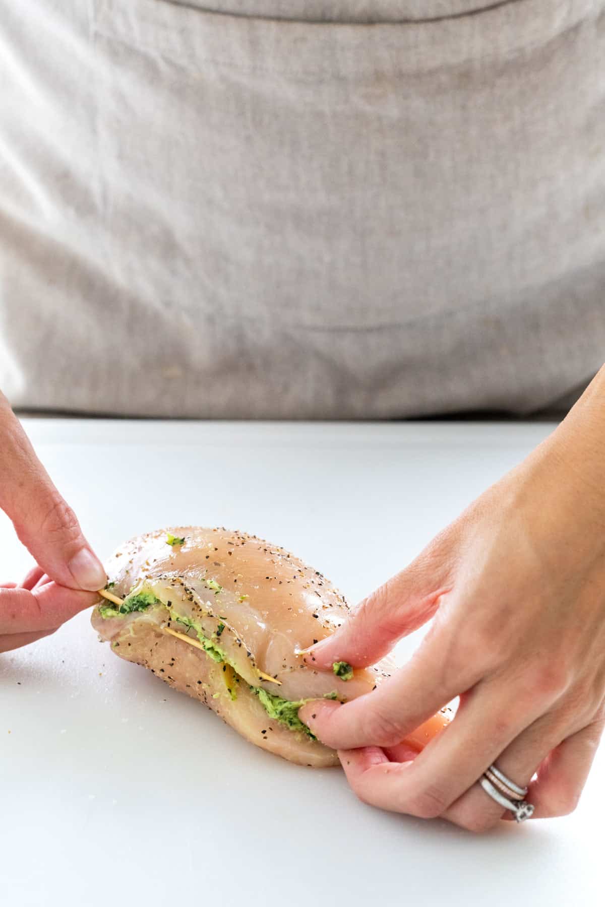Sealing the chicken pocket with a toothpick.