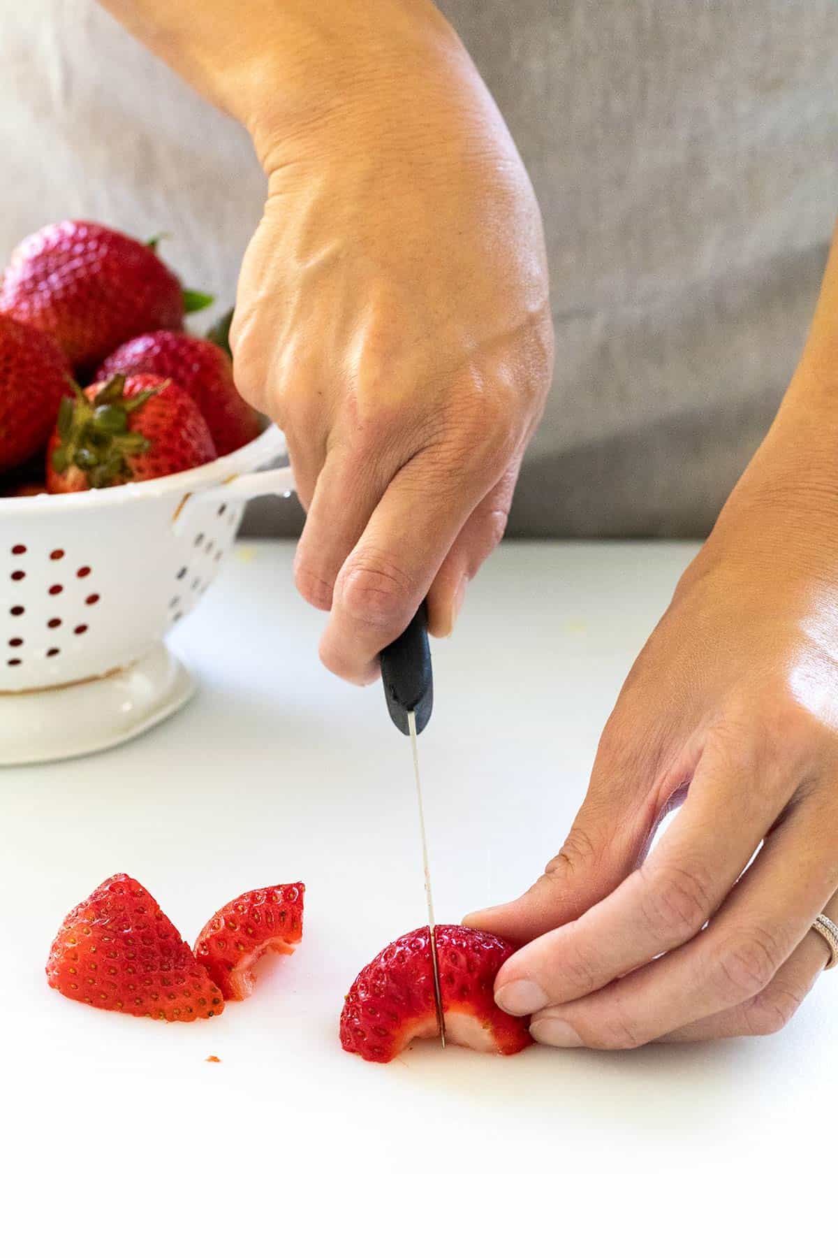 Cutting strawberries in quarters.