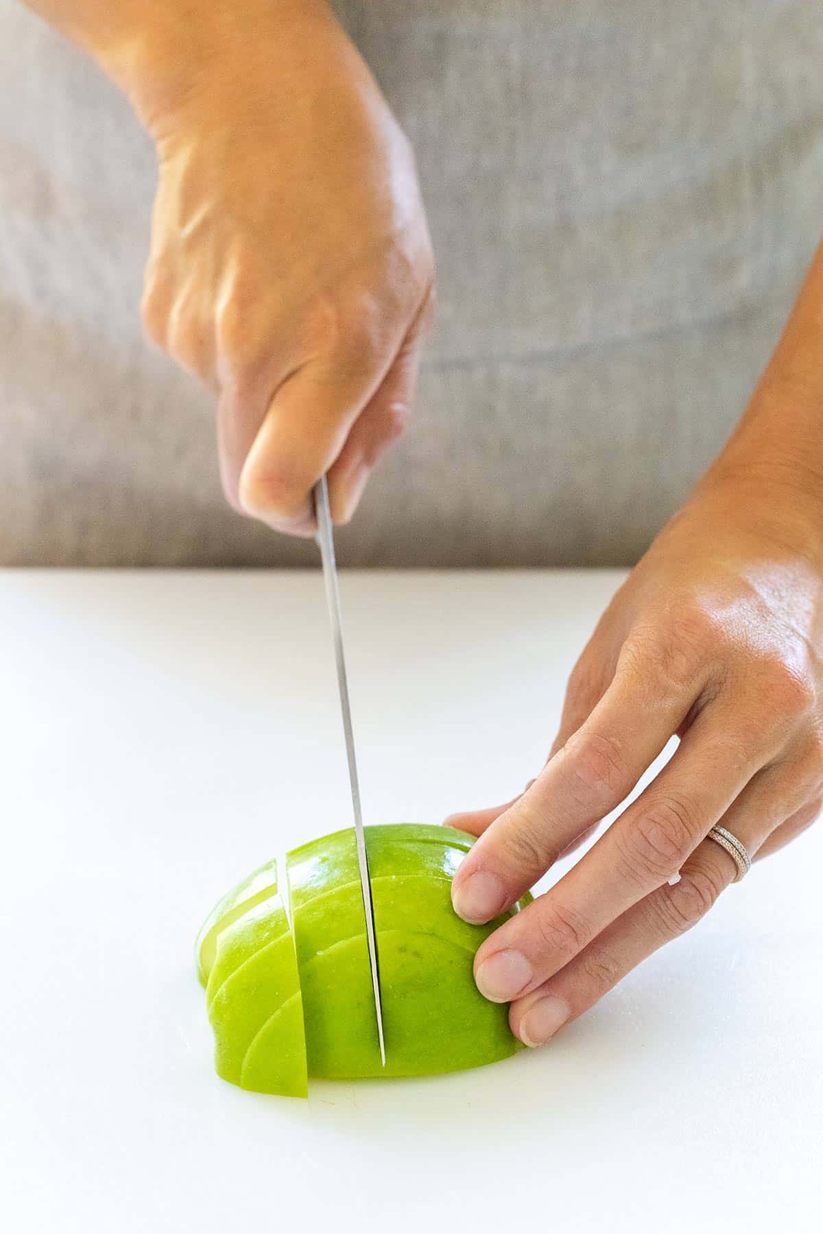 Cutting green apple into small pieces.