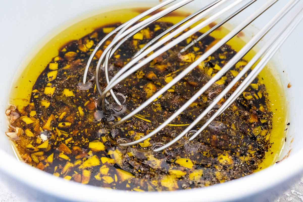 Bowl of marinade ingredients and a whisk to mix everything together.