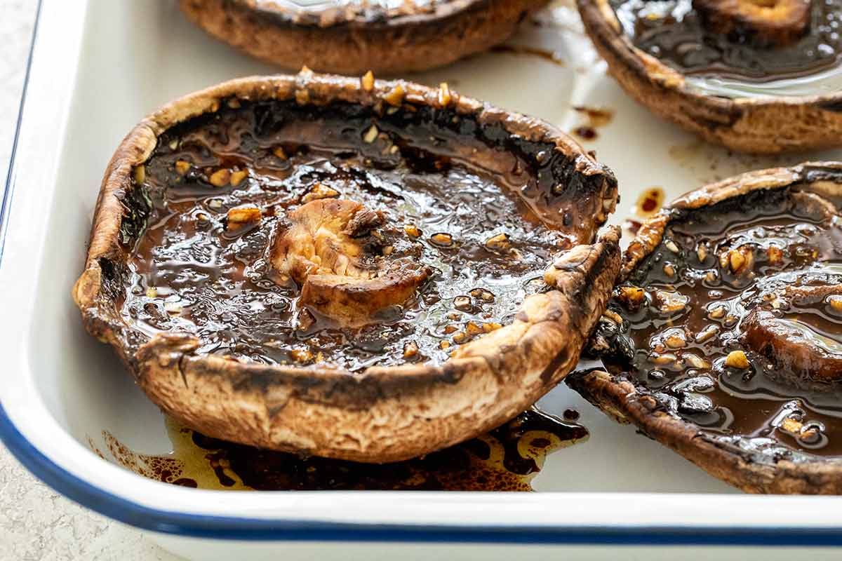 Portobello mushroom caps soaking in a marinade mixture.