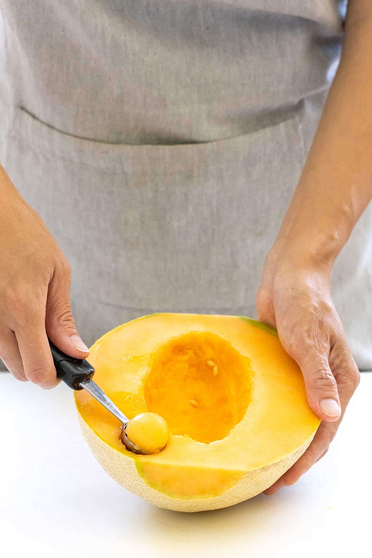 Melon baller making cantaloupe spheres.