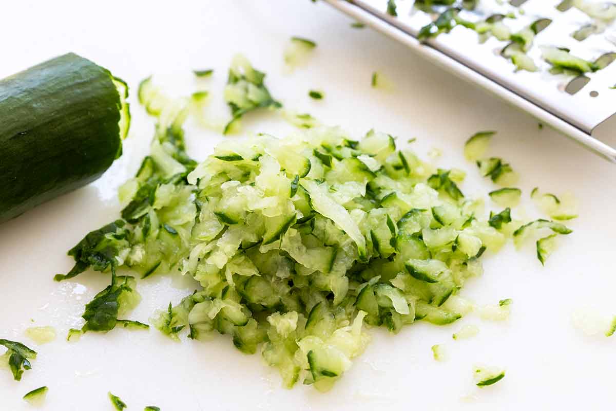 Grated cucumber on a cutting board.